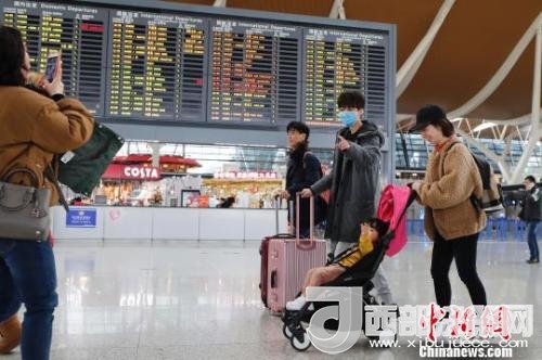 旅客帶著孩子前往辦票柜臺辦理登機手續(xù)。　殷立勤 攝