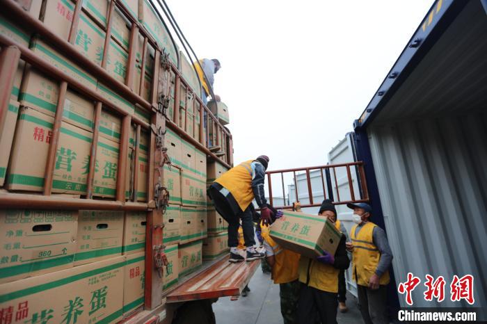 圖為鐵路裝卸作業(yè)人員正在將云南特色農(nóng)產(chǎn)品裝入集裝箱?！詈?攝