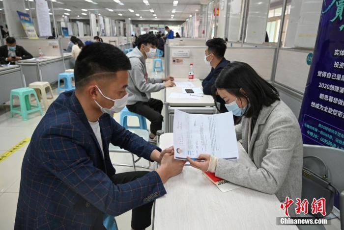 4月14日，招聘者在查看求職者簡歷。<a target='_blank'  data-cke-saved- >中新社</a>記者 王剛 攝