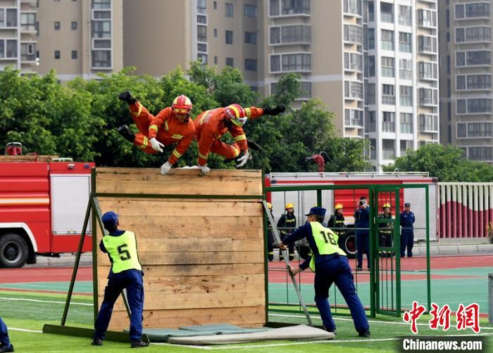 新消防員進(jìn)行消防障礙接力操展示?！⒅铱?攝