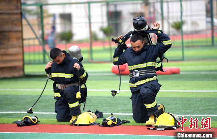 新消防員進(jìn)行穿戴空呼器展示?！⒅铱?攝