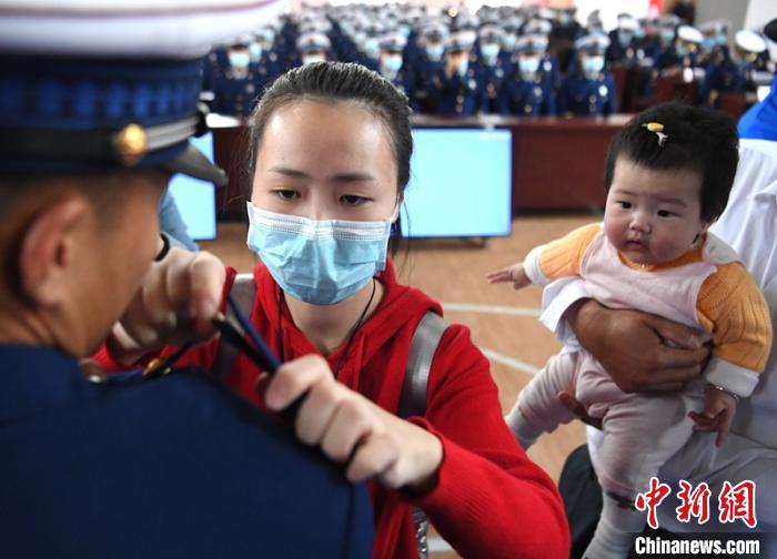 新消防員楊振的妻子彭莉與女兒現(xiàn)場(chǎng)見(jiàn)證丈夫加入“火焰藍(lán)”的神圣時(shí)刻?！⒅铱?攝