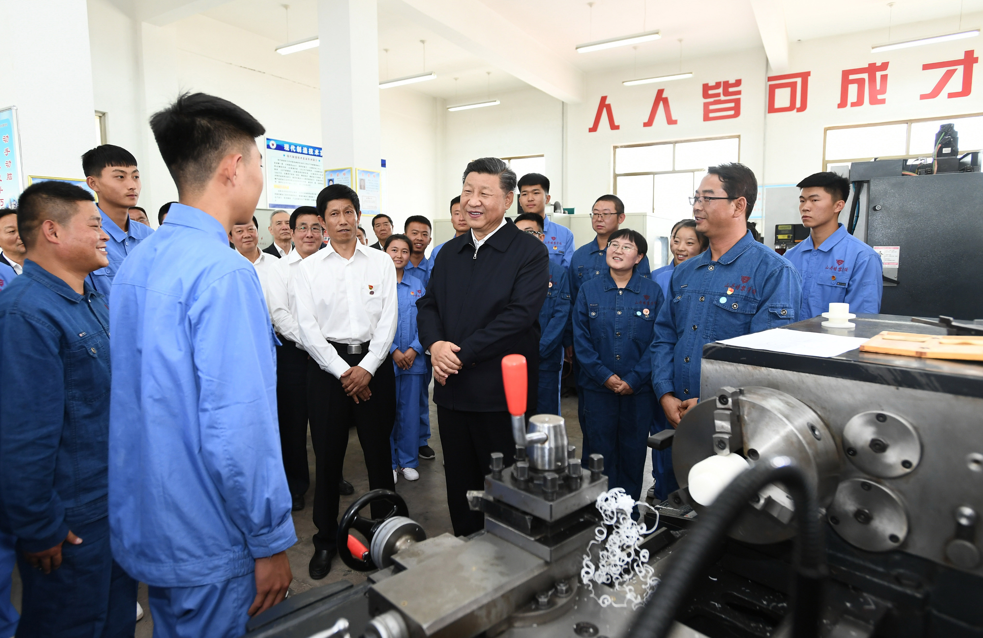 2019年8月20日，習(xí)近平在甘肅省張掖市山丹培黎學(xué)?，F(xiàn)代制造技術(shù)實(shí)訓(xùn)室，觀看職業(yè)技能實(shí)訓(xùn)，同師生親切交流。