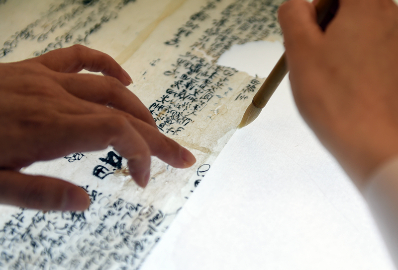 2022年5月17日，在安徽博物院文物科技保護(hù)中心紙質(zhì)文物修復(fù)室，工作人員對(duì)古籍文物進(jìn)行補(bǔ)全。