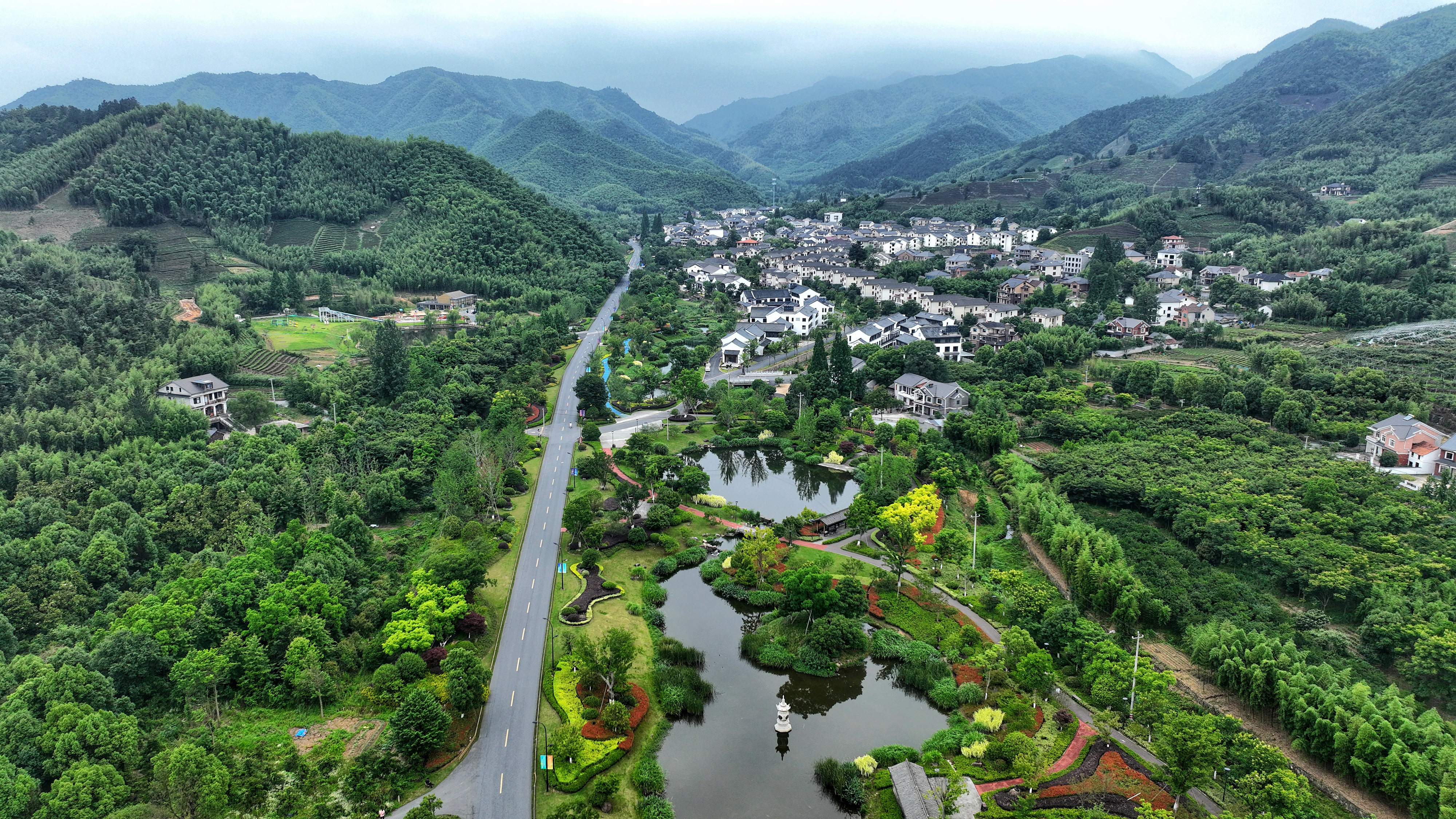 2023年6月6日，杭州余杭區(qū)徑山鎮(zhèn)鄉(xiāng)村，生態(tài)碧水、沿路花海與村莊農(nóng)房相映成趣，構(gòu)成一幅美麗的山水田園畫。