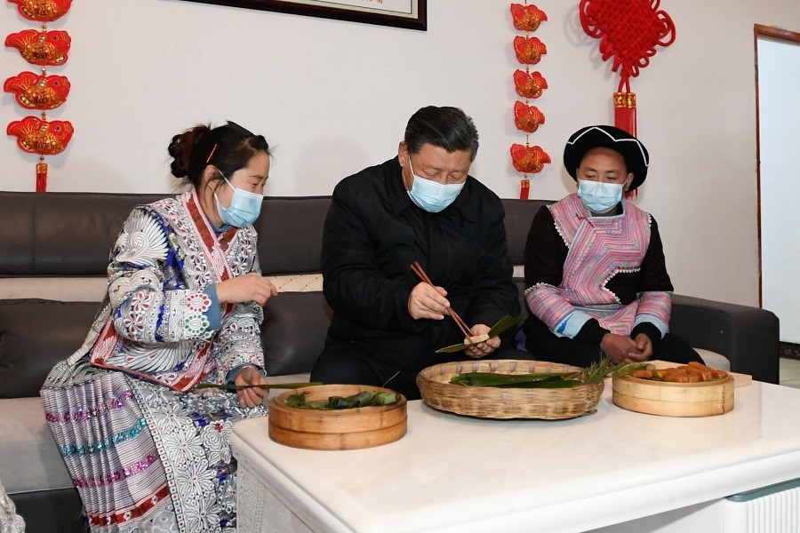 2021年2月3日下午，習(xí)近平在貴州畢節(jié)市黔西縣新仁苗族鄉(xiāng)化屋村苗族村民趙玉學(xué)家，同一家人邊聊家常邊制作當(dāng)?shù)貍鹘y(tǒng)節(jié)日食品黃粑。新華社記者 李學(xué)仁 攝